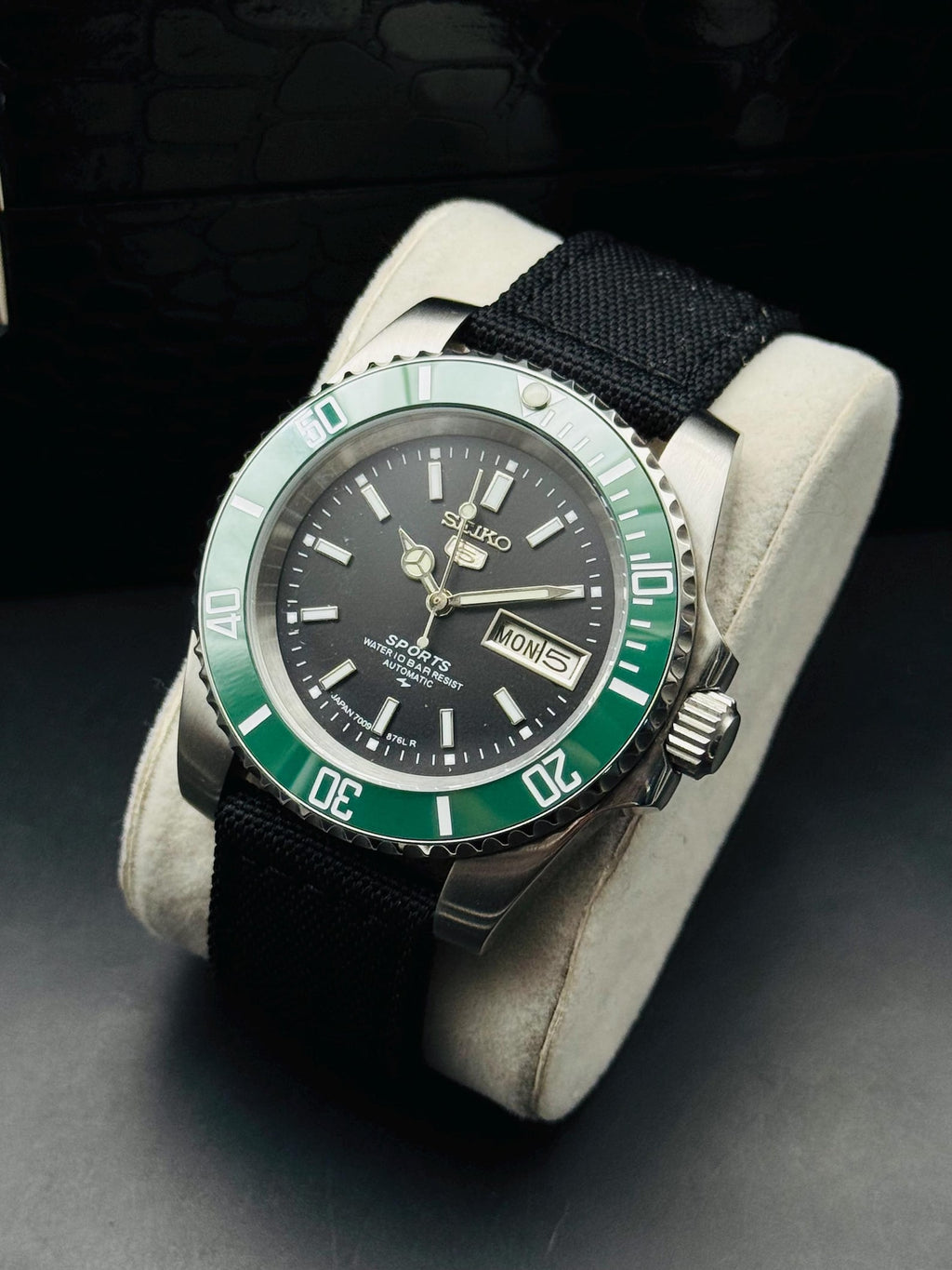 Seiko 5 Sports automatic with green rotating bezel on display cushion