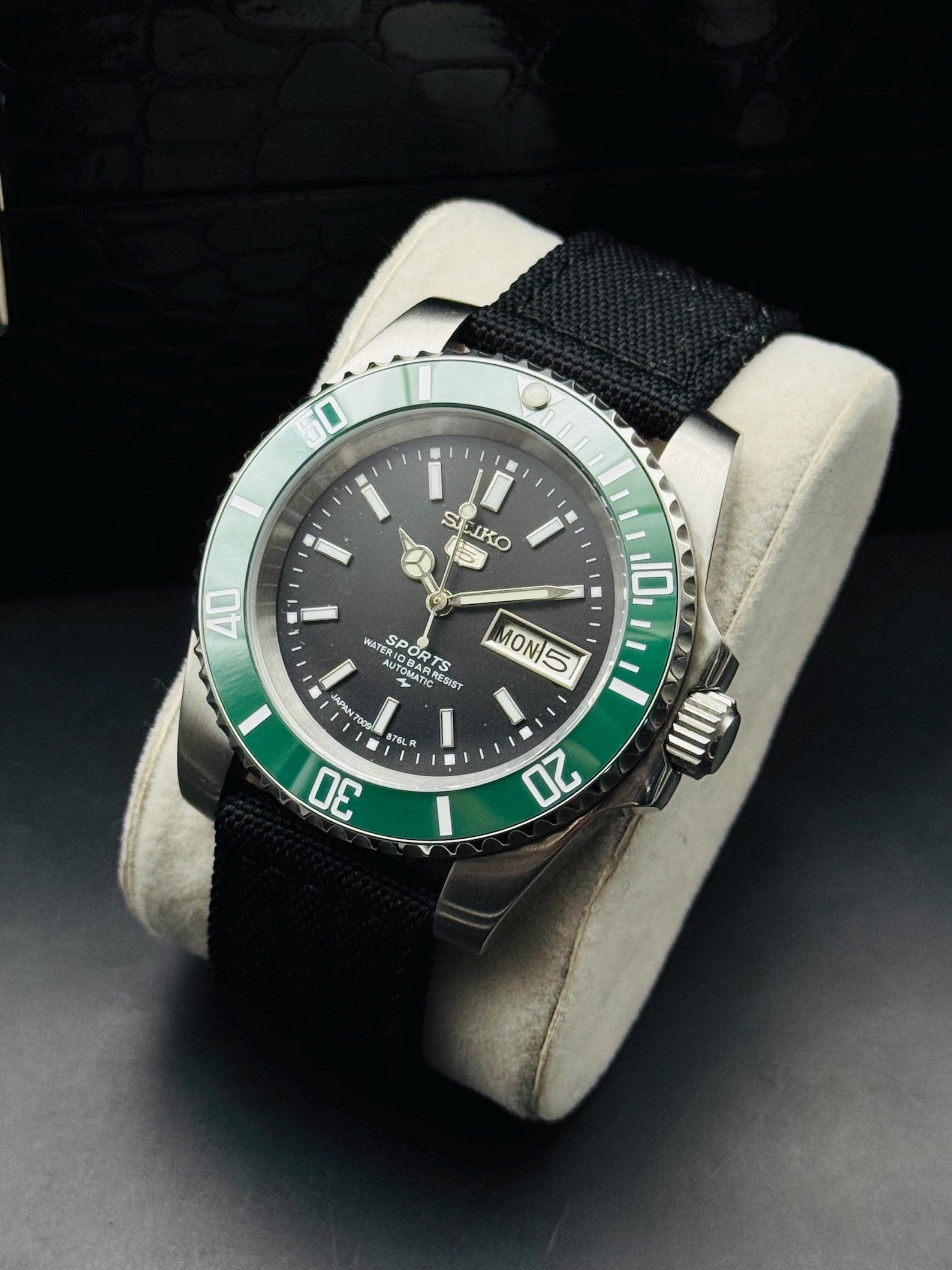 Seiko 5 Sports automatic with green rotating bezel on display cushion