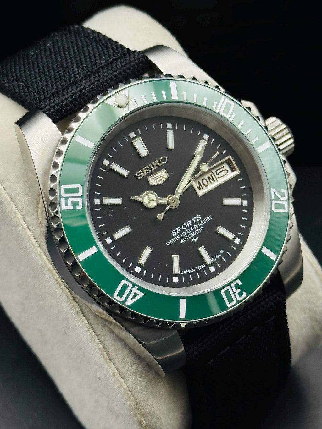 Close view of black Seiko 5 Sports dial and day-date display