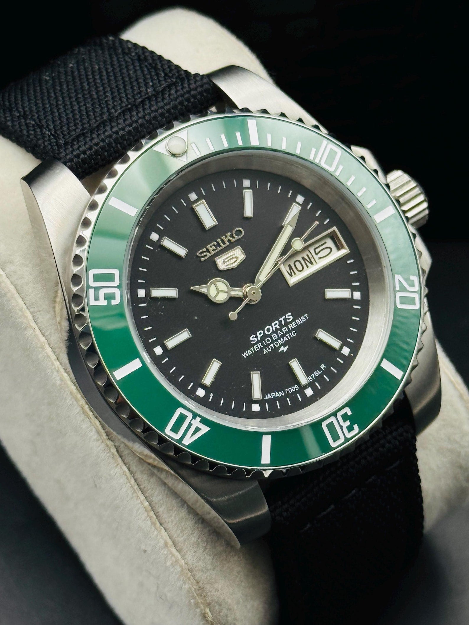 Close view of black Seiko 5 Sports dial and day-date display