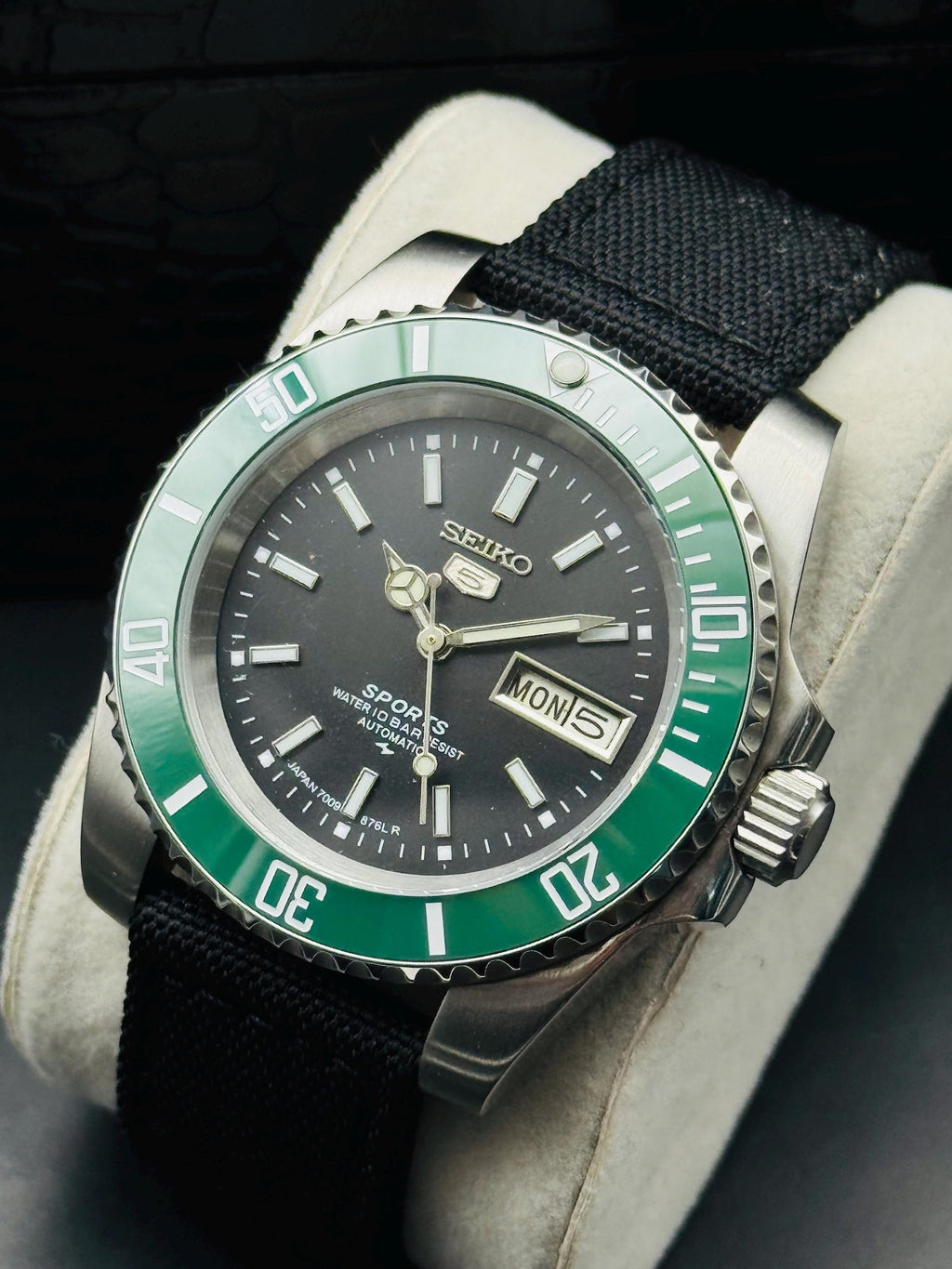 Detailed view of Seiko 5 Sports black dial and luminous-style markers