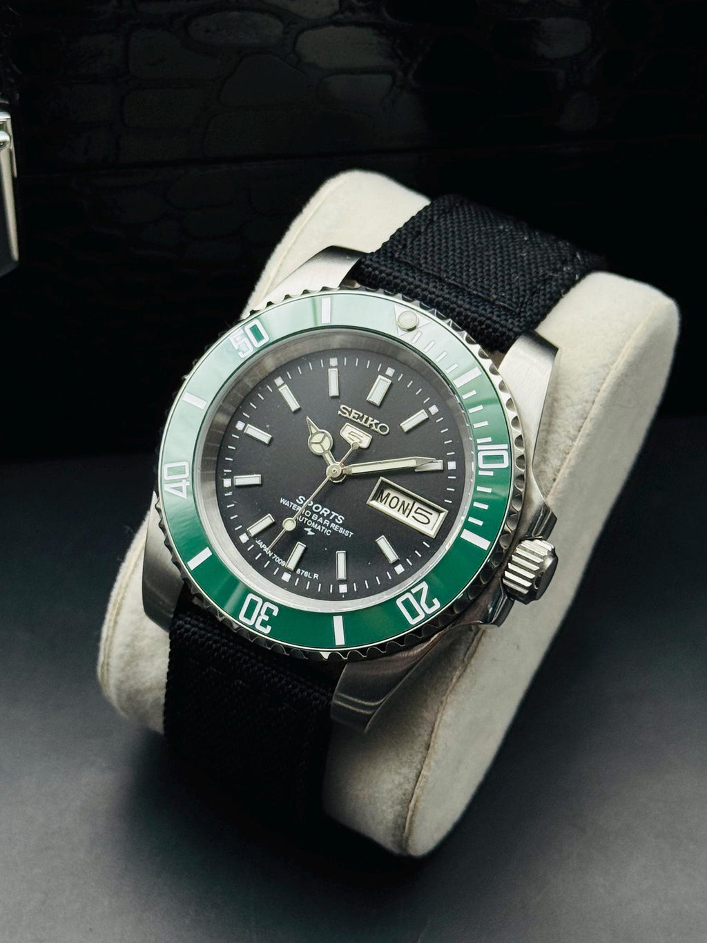 Angled product view of green-bezel Seiko automatic watch