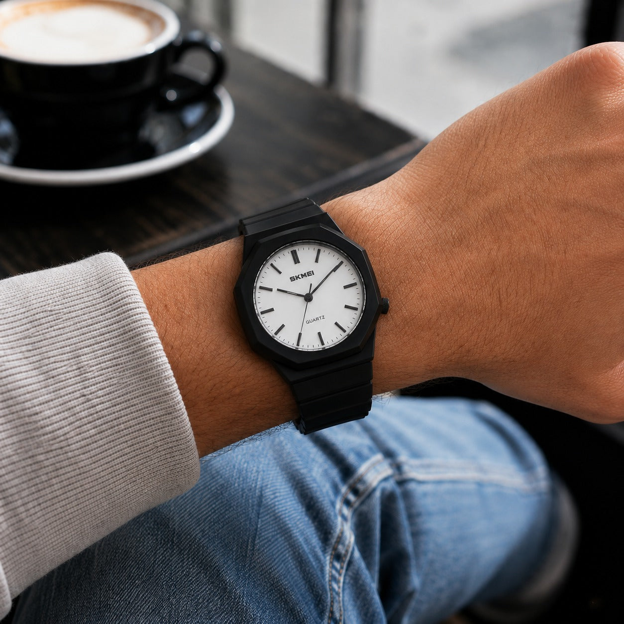 SKMEI 1717 quartz watch, black case with white dial, worn on the wrist at a cafe table