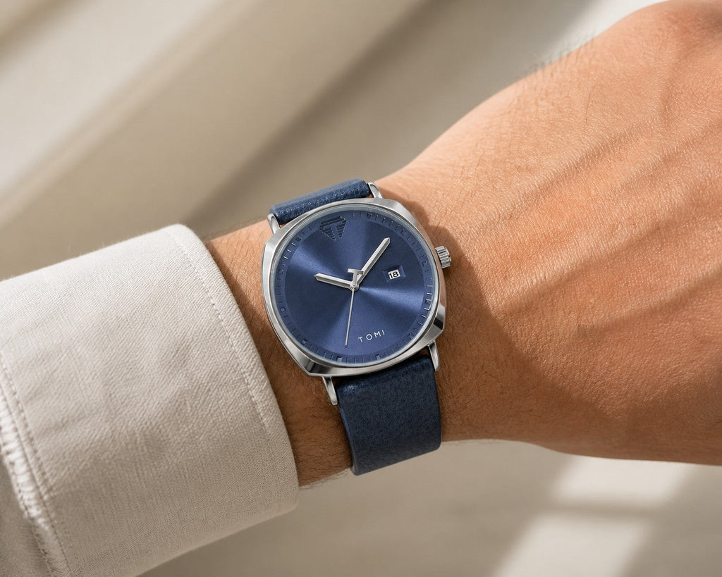 TOMI blue dial and silver case quartz watch worn on the wrist