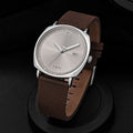 TOMI minimalist calendar quartz watch with silver case, silver dial, and brown leather strap