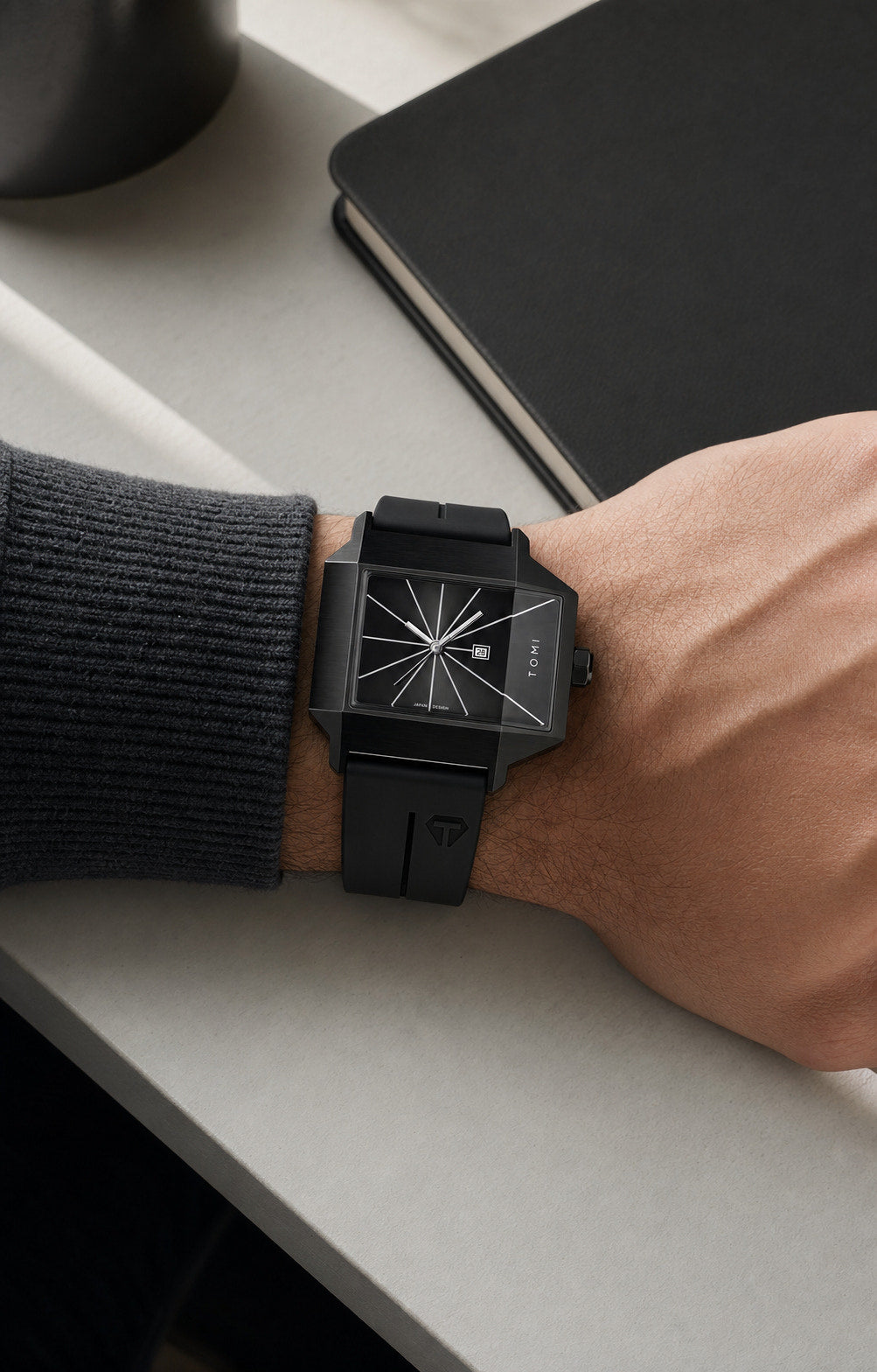 TOMI T021 black square watch worn at a modern desk